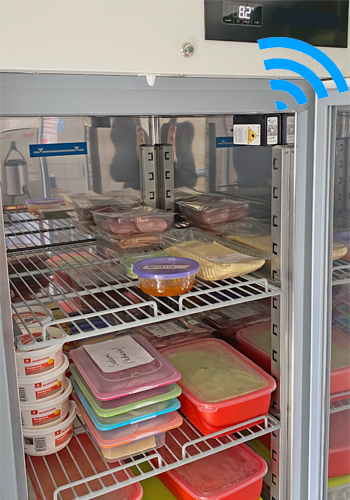 Das Foto zeigt eine WLAN Temperatur Messeinheit, die im Inneren eines KITA oder Hort Kühlschranks installiert ist. 